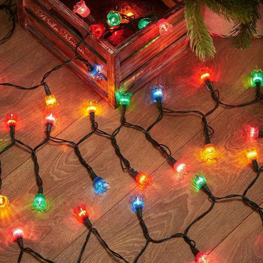 NOMA multicolour canterbury belles LED string lights laid out on a wooden floor