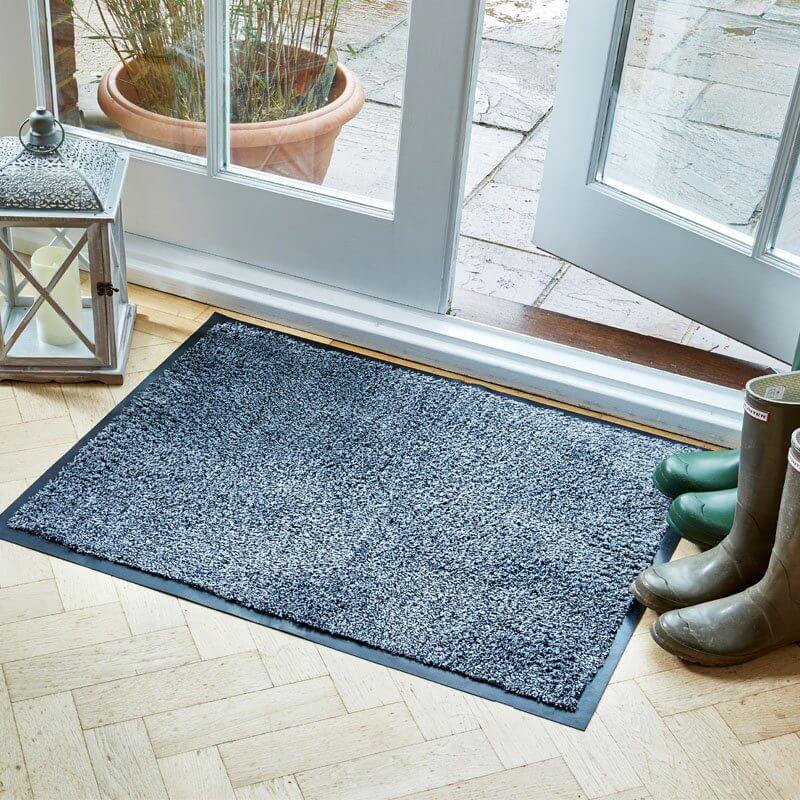Framed anthracite Ulti-Mat washable indoor doormat on a wood floor by a patio door, with wellington boots