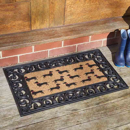 Dachshund dog print coir doormat insert in rubber frame on a porch step, with wellington boots