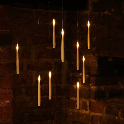 Noma Magic Candles with Wand lit and hanging, creating a floating candle effect against a brick wall