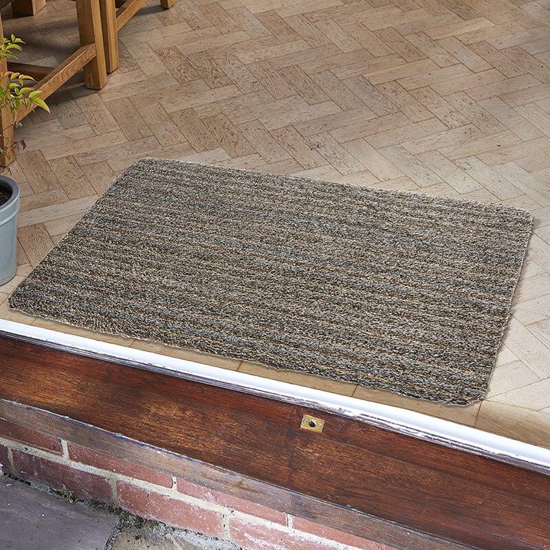Striped Ulti-Mat washable indoor doormat in grey and brown tones on a tiled floor by a door