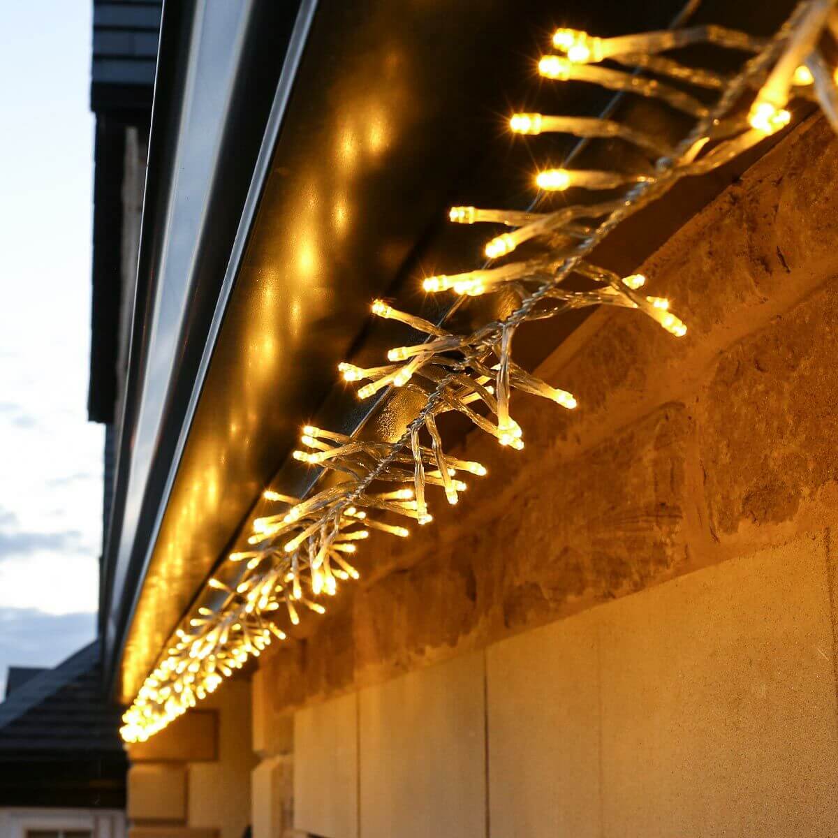 String of warm white cluster lights hung along house guttering