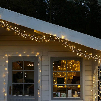 String of warm white cluster lights on a house exterior at night